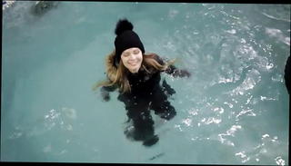 Watch the video about Wetlook girl with winter clothes swims in the pool